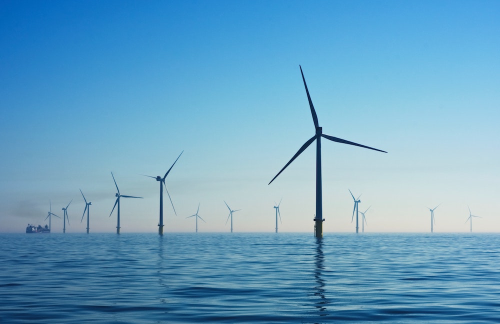 An ocean wind farm at dusk.