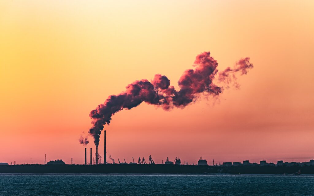 Sunset skyline with chimney emitting smoke or steam